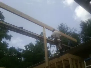 Carpenter setting a ridge beam over a new addition frame — Ice Dam Removal by Roofing Brothers in Boyd