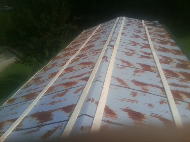 Rusted metal roof panels with new wood purlins before replacement — Storm Damage Roof Repair in Boyd by Roofing Brothers