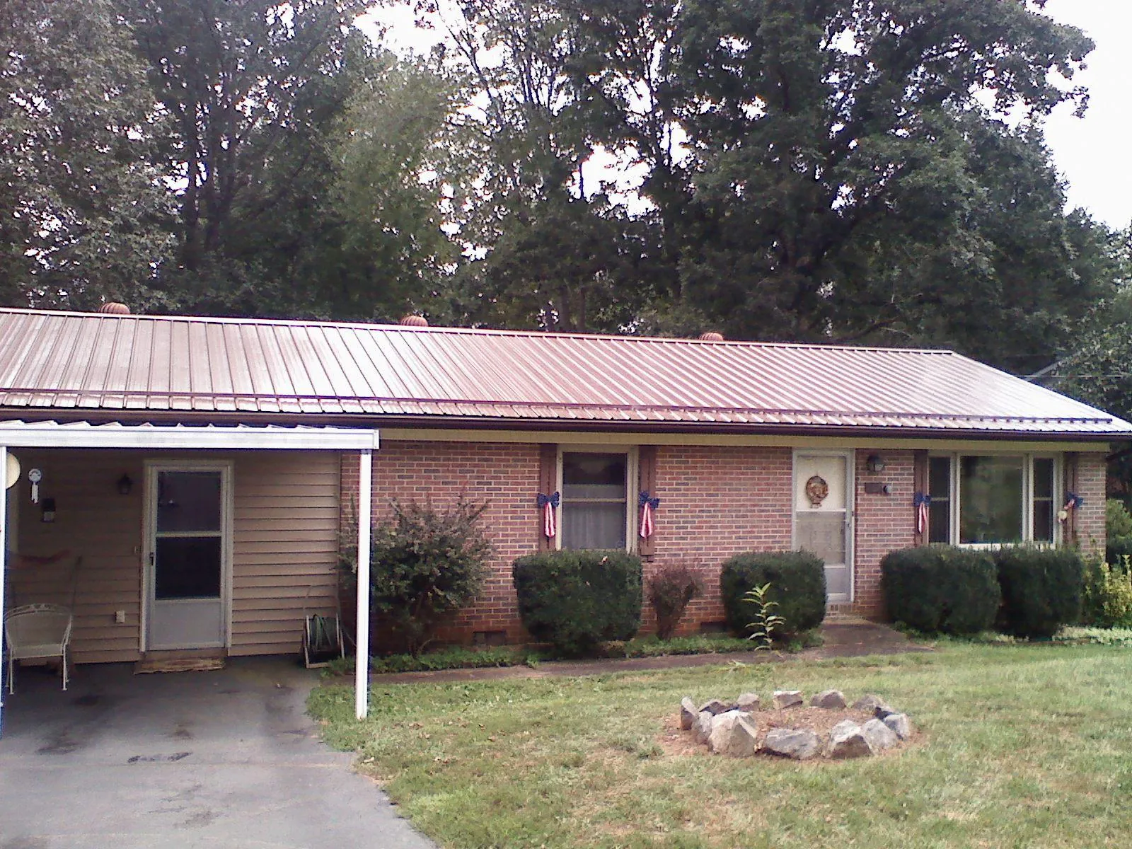 Bronze metal roof and carport on a brick ranch home — Roof Repair work by our crew in Boyd